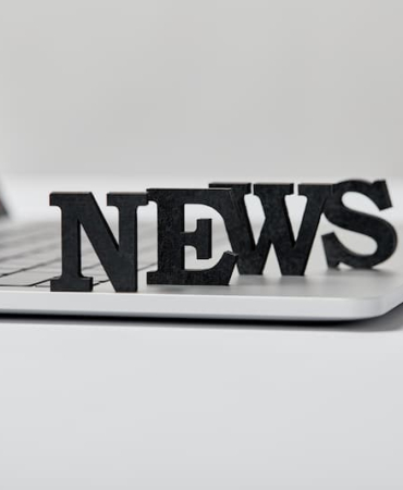 selective-focus-of-black-news-lettering-near-lapto-2024-11-19-12-28-50-utc-1