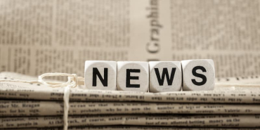 wooden-blocks-spelling-news-on-stack-of-newspapers-2026-03-16-01-24-14-utc